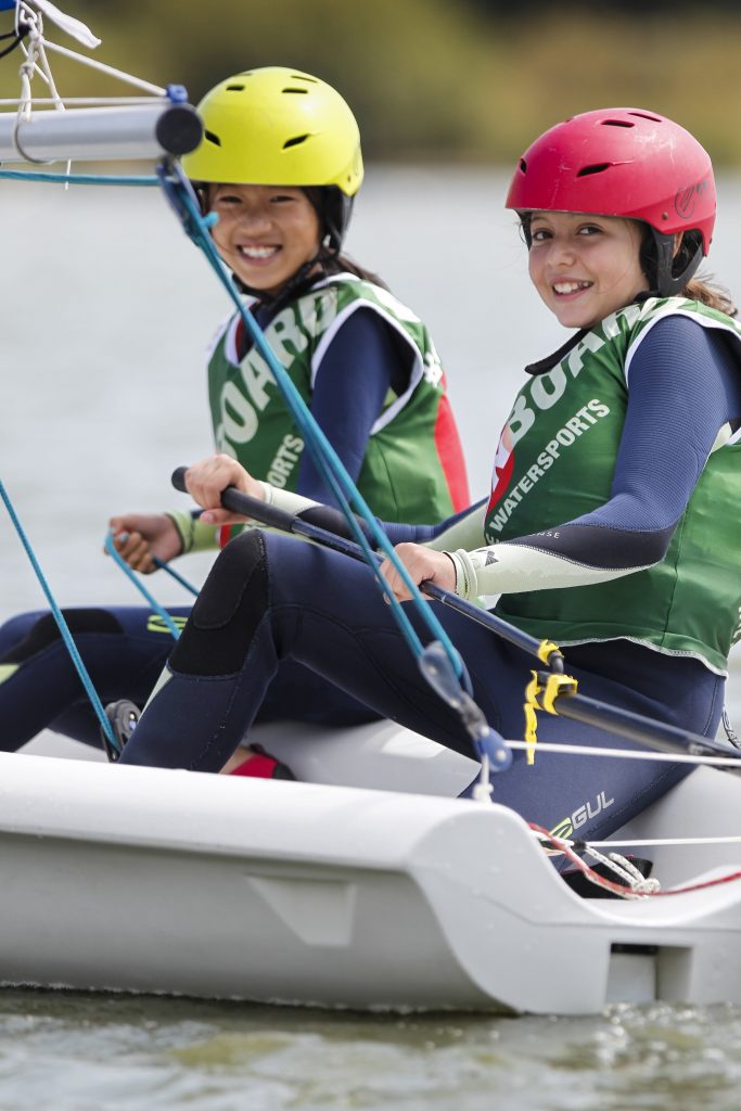 2 kids smiling whilst sailing