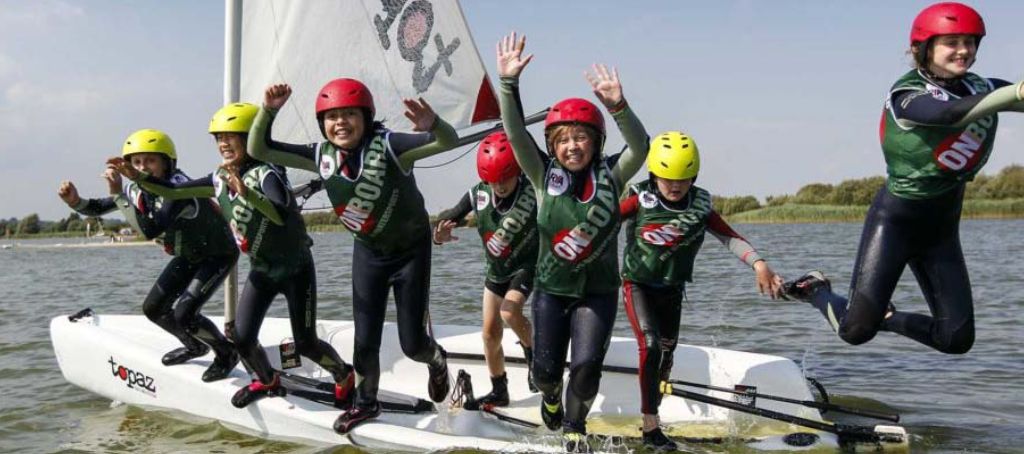 Children laughing jumping off of sailing boat