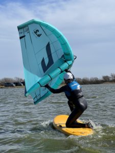 man learning to wingsurf on his knees