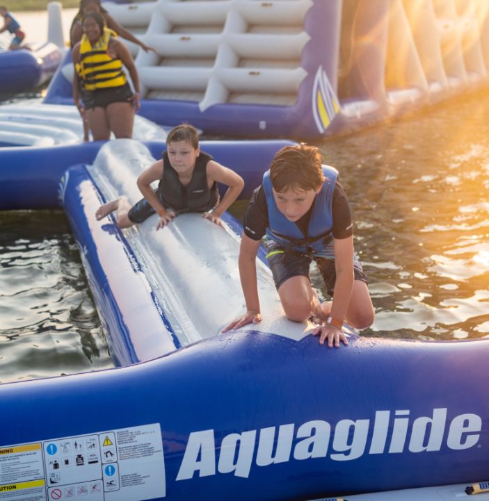 people crawling on balance beam at aquapark near rye