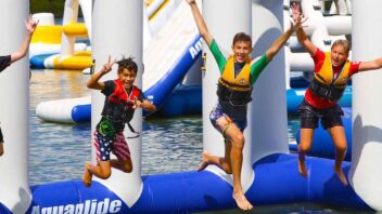 children jumping off aquapark inflatable into the lake at rye watersports