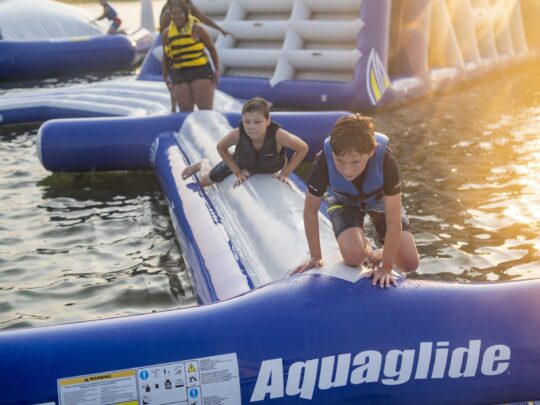 people crawling on balance beam at aquapark near rye