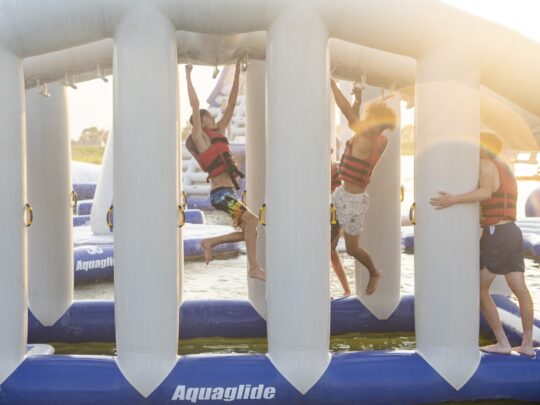 people hanging from monkey dome aquapark inflatable in rye near camber sands